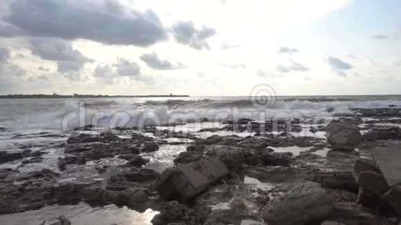 在海上冲浪波浪在海岸的岩石上破碎和飞溅视频的预览图