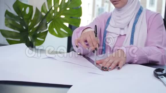 小企业和爱好概念穆斯林妇女时装设计师在裁缝店的桌子上钉纸图案视频的预览图