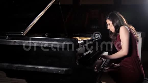 美丽的年轻女子在音乐厅弹钢琴排练视频的预览图