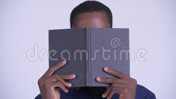 年轻的非洲书呆子商人的脸带眼镜用书遮住脸视频的预览图