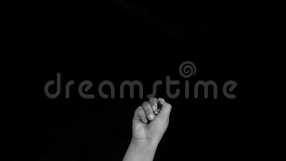 一只女性的手带来了旧的老式传统风格的银耳环隔离在黑色背景视频的预览图