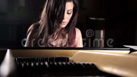 年轻悲伤的迪什卡伊格拉特在钢琴钢琴弦琴视频的预览图