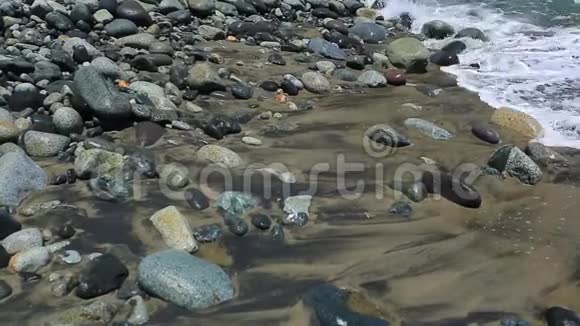 波浪爬上灰色的石头舔它们静修录像视频的预览图
