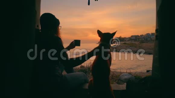 年轻女子和狗一起喝茶或咖啡视频的预览图