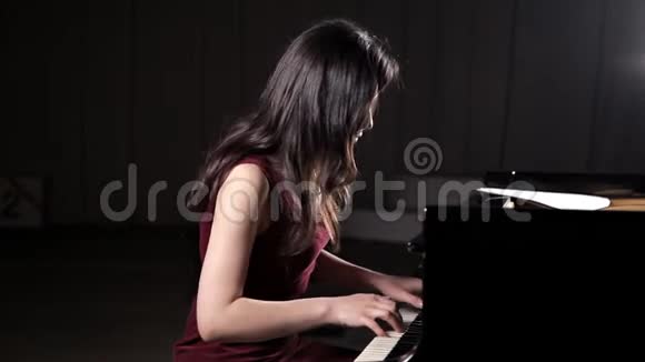 美丽的年轻女子在音乐厅弹钢琴排练视频的预览图