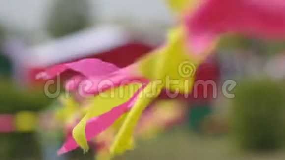 五彩斑斓的节日小旗红黄飘摇在风中飘扬装饰背景缓慢视频的预览图