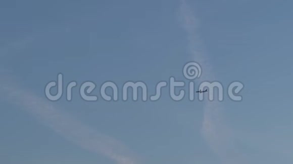 傍晚蓝色的天空一架飞机在云层中高高飞起生动的金色一小时日落紫色和粉红色视频的预览图