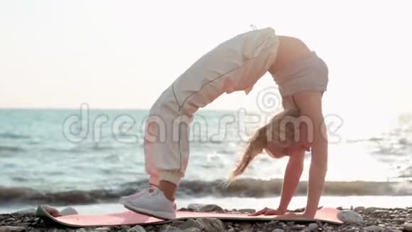 一位身材矮小运动力强的海边女子仰着腰背起身来双手放在地板上锻炼身体以保持身体健康视频的预览图