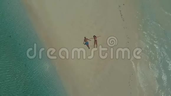 在菲律宾的沙洲上无人机在绿松石水上升起一对旅伴躺在沙滩上视频的预览图