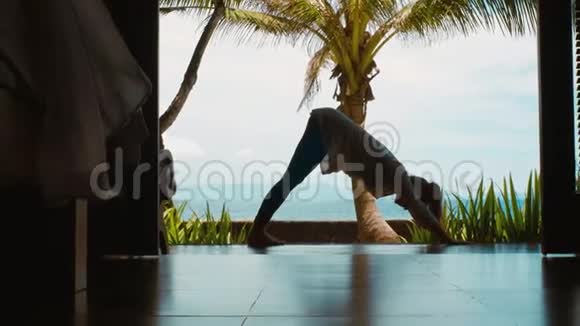 女人的剪影在山上练习瑜伽伸展腿在海滩上美丽的巴厘岛风景自然的声音视频的预览图