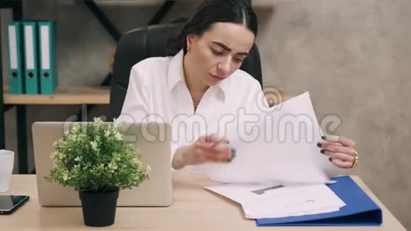 疲惫的女人在办公室工作喝咖啡视频的预览图