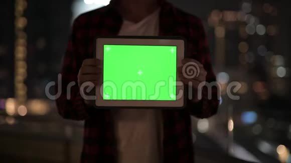 青年男子展示数码平板电脑与城市夜景对比视频的预览图