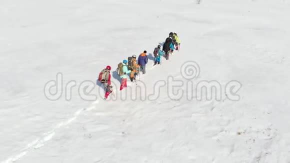 一群装备精良的游客疲劳铺平了道路明亮的冬日穿过雪地使用你的设备视频的预览图