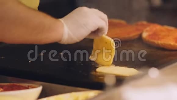 厨师把奶酪片分解在一个热金属盘子里在厨房准备三明治吃早餐视频的预览图