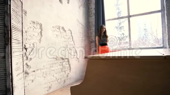 站在白色大钢琴后面的漂亮女孩视频的预览图