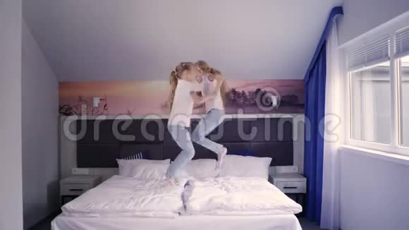 快乐的双胞胎在床上跳跃视频的预览图