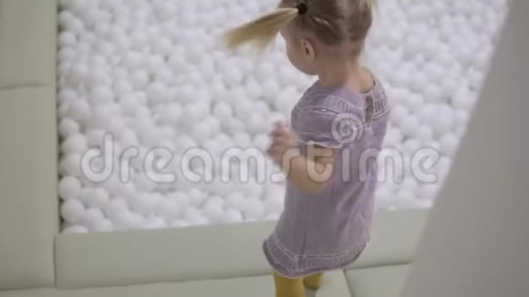一个小女孩带着一堆白球跳进游泳池视频的预览图