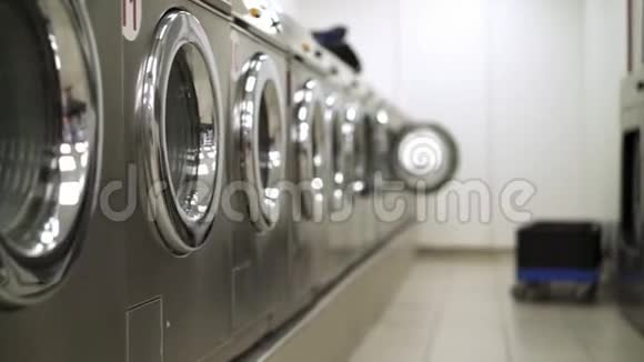 洗衣房里的一排银色洗衣机视频的预览图