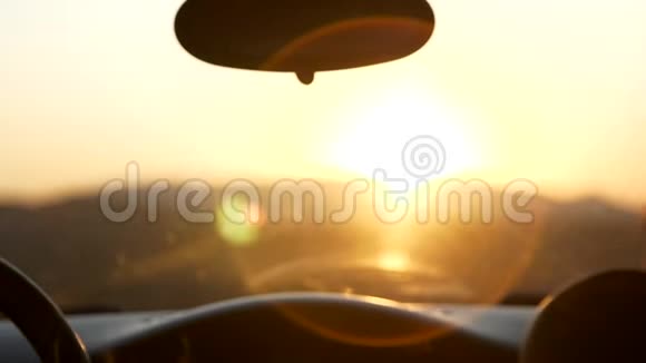 两个年轻的女人坐在车里看日落夕阳西下视频的预览图