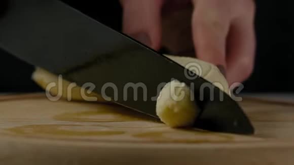 特写慢镜头女人的手在厨房板上切香蕉视频的预览图