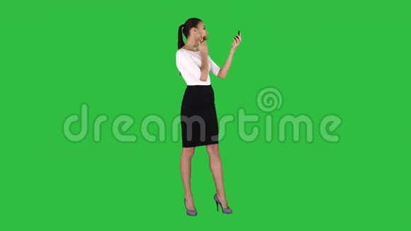 化妆年轻女性模特将化妆刷涂在绿色屏幕上铬键视频的预览图