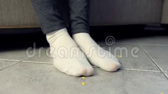 女人在沙发上吃饭在地板上把玉米片弄碎腿部和地板特写视频的预览图