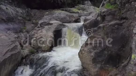 一条有水力发电站管道的山河石间美丽的瀑布视频的预览图