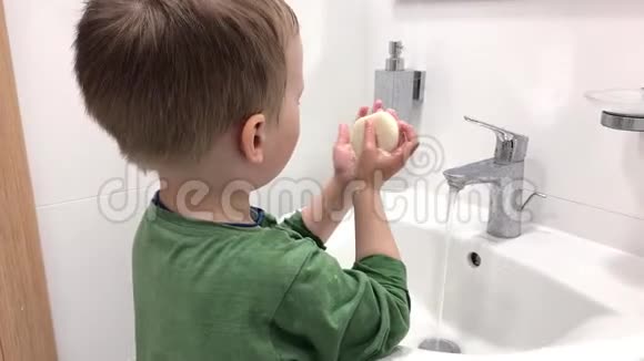 一个小孩用肥皂在水槽上洗手视频的预览图