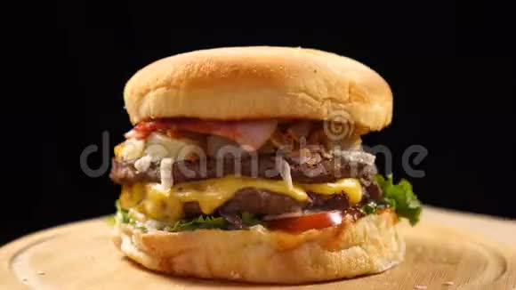 新鲜开胃的汉堡在黑色背景上快速旋转无缝可循环射击视频的预览图