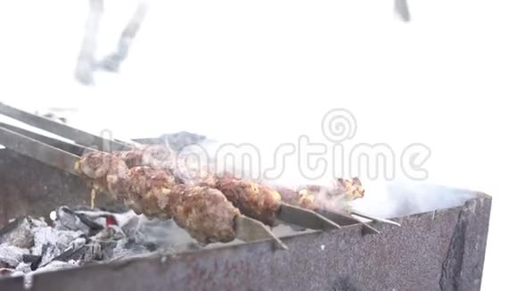 一个人手在煮什什卢勒串冬天在木炭烤架上煎肉户外下雪视频的预览图