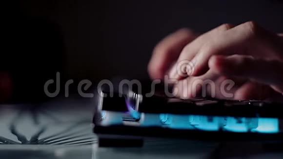 在黑暗的房间里程序员在背光键盘上输入代码在电脑上热情地工作视频的预览图