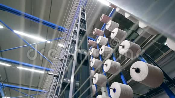 缝纫线轴与白色螺纹翘曲在他们现代纺织厂视频的预览图