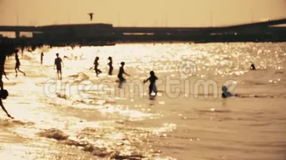 人们在黄金时间在海滩上放松和玩耍视频的预览图