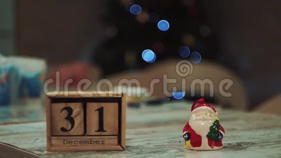 12月31日圣诞老人在桌上用木立方体雕刻背景模糊闪烁视频的预览图