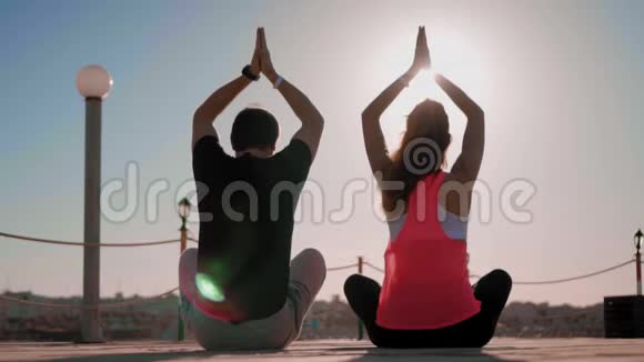 情侣坐在日落背景上做瑜伽永恒地寻求和谐心灵和身体视频的预览图