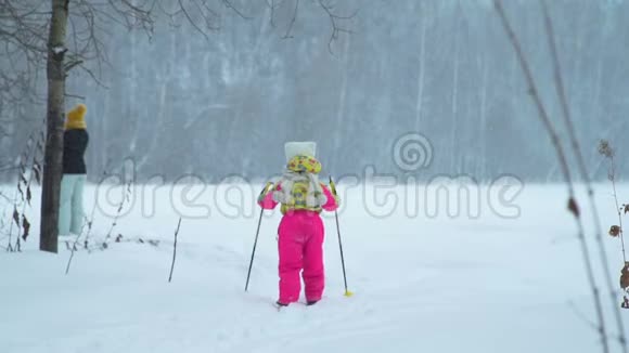 女孩正努力赶上母亲滑雪视频的预览图
