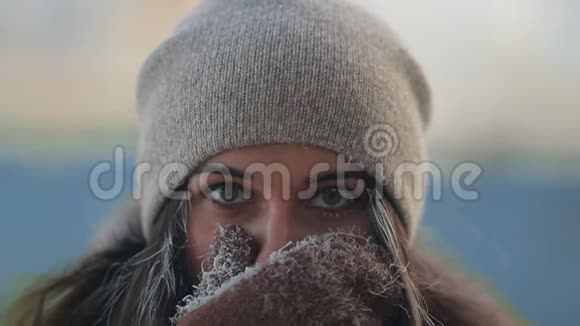 一个年轻迷人的女人从寒冷中用手遮住她的脸的肖像视频的预览图
