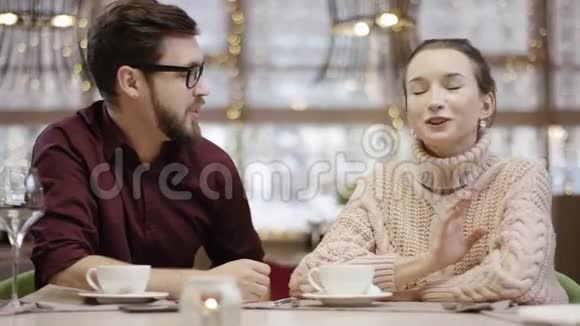 成年男人和不高兴的女人在餐馆里一桌一桌地交谈视频的预览图