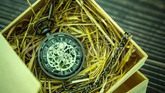 时光流逝口袋手表卷绕机在天然麦秸在一个木箱视频的预览图
