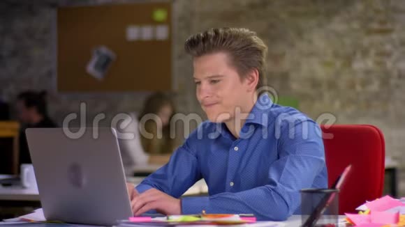 中年金发商人在笔记本电脑前面临麻烦和烦躁地躺在椅子上的肖像视频的预览图