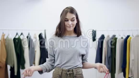 一位年轻漂亮的女士在一间服装店里摆着两个卖包视频的预览图