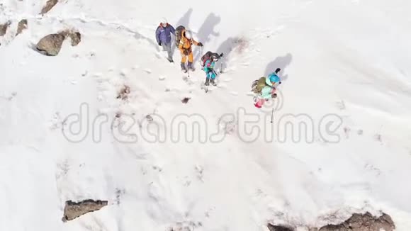 四名游客爬山帮助自己滑雪杆空中射击与四翼旋转相机视频的预览图