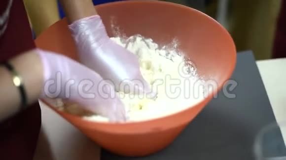 女孩用面粉和黄油做面团一个戴手套的厨师能防止面粉视频的预览图