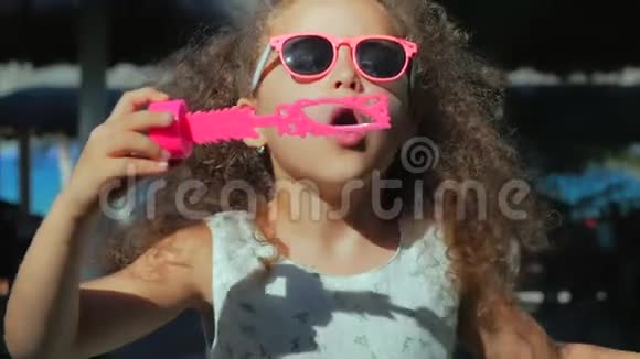 快乐的小女孩在户外玩耍吹肥皂泡在后院玩得很开心自然公园里美丽的孩子视频的预览图