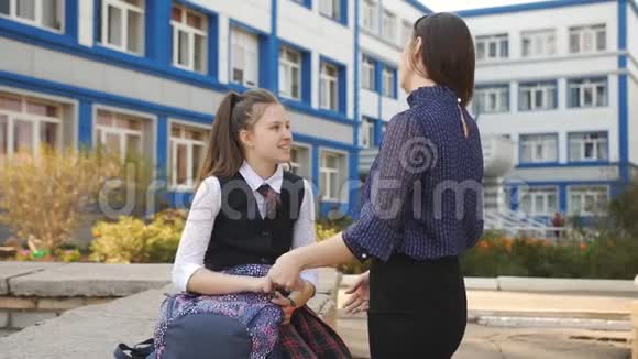 在大学附近和妈妈聊天的少女妈妈和女儿下课后在大学外交流视频的预览图