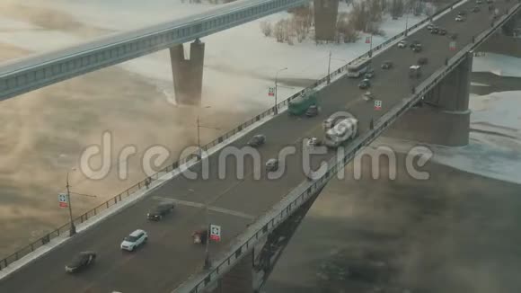 汽车和公共汽车穿过神秘的桥这条河被蒸汽覆盖了视频的预览图