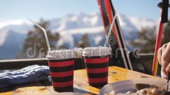 午餐时间几个滑雪者在山上喝着覆盖的葡萄酒天空上有覆盖着酒的特写杯视频的预览图