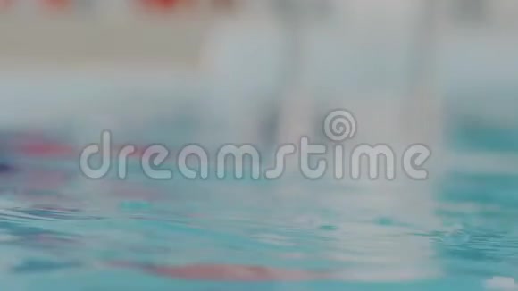 超级宏观画像年轻的职业游泳女子戴着红色游泳帽从游泳池里的水中出来她是视频的预览图