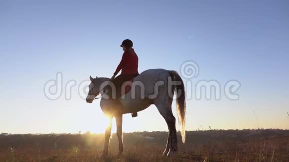 一个女人骑在田野中间的马背上慢动作侧视图视频的预览图