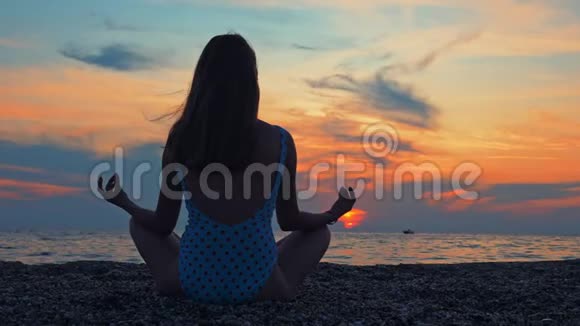 年轻女性在日落时在海边或海洋练习瑜伽视频的预览图